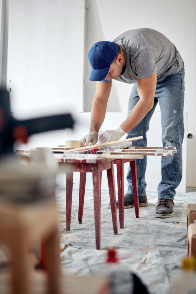 Young adult man working on a DIY budget renovation of his new home apartment.