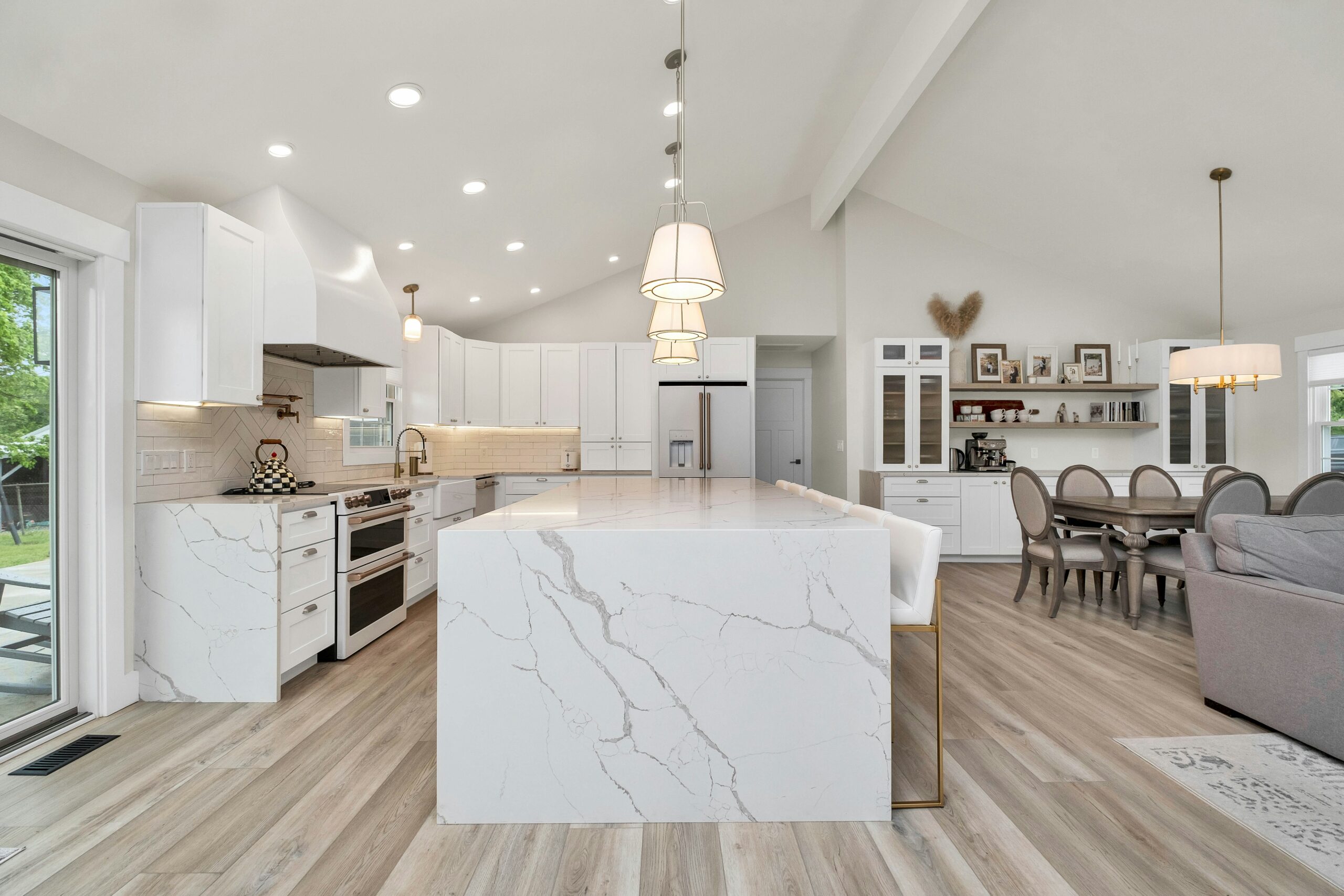 white and grey living room and kitchen with beautiful lights